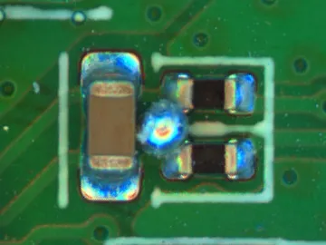 Solder ball between mounted components, with surrounding pads visible